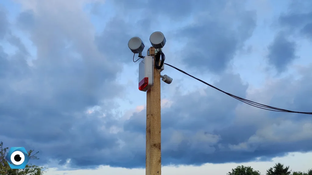 Słup z systemem monitoringu budowy bez stałego łącza internetowego, wyposażony w most radiowy, sygnalizator alarmowy oraz kamerę.